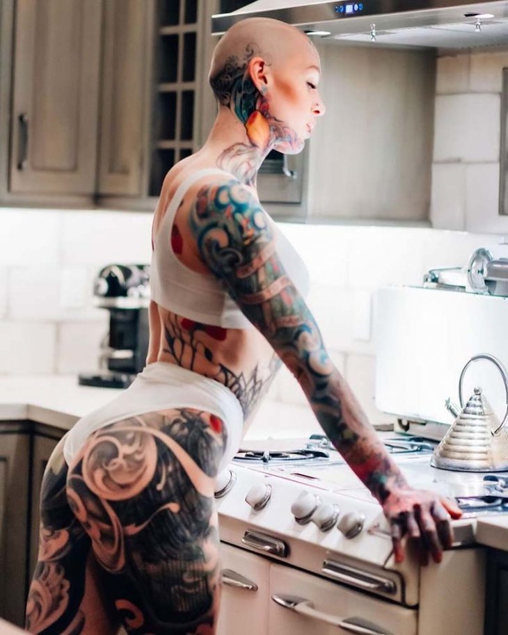 Гламурная дамочка обливает маслом свое татуированное тело