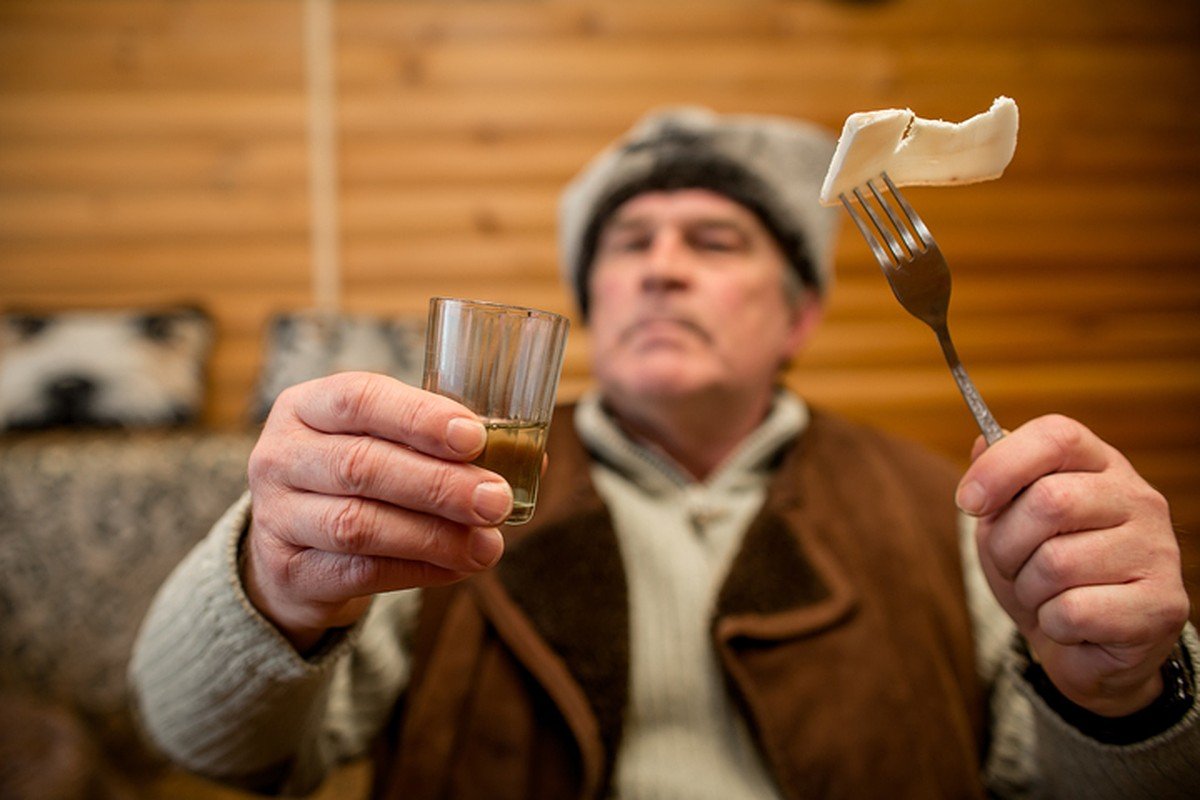 Русские мужики пьют. Мужики пьют за столом в деревне.